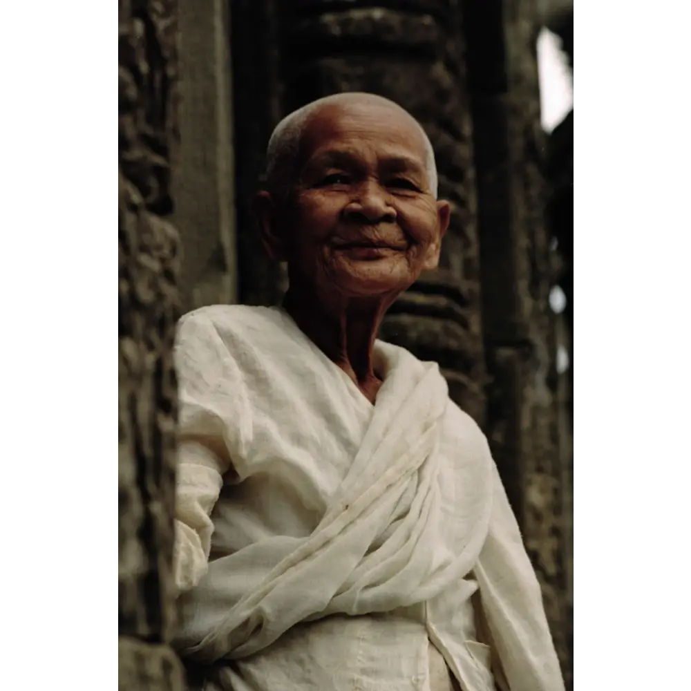 Femme âgée souriante en blanc.