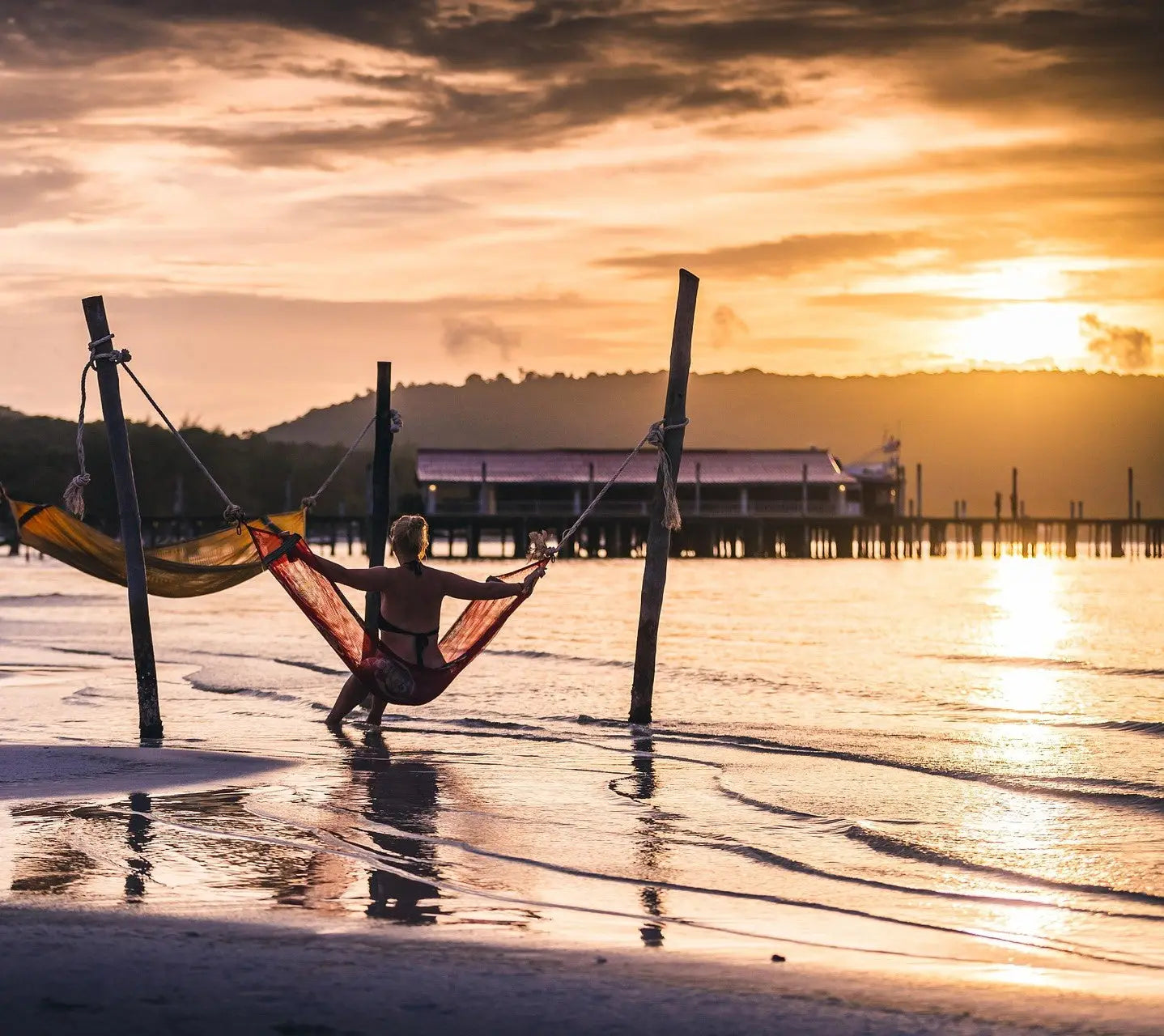 Hamac sur une plage au coucher du soleil.