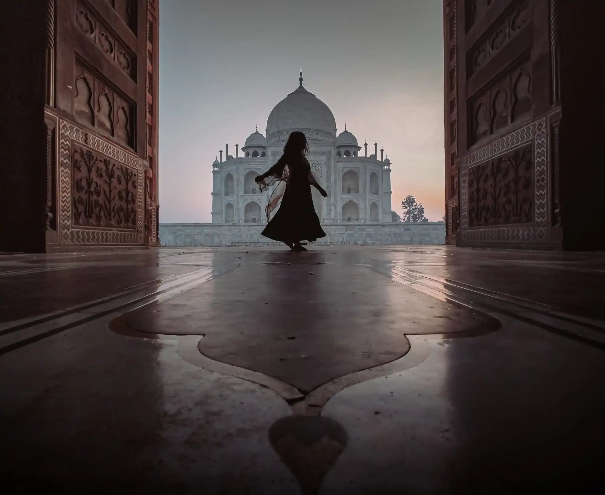 Une silhouette en robe fluide tournoyant devant le Taj Mahal.